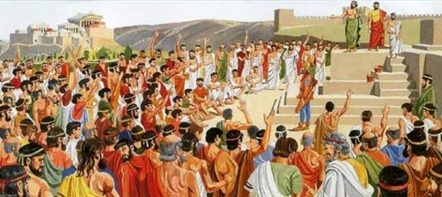 A roman ekklesia is seen with a crowd of men of all ages surrounding a tall stone podium where a few are speaking. Many hands in the crowd are raised.